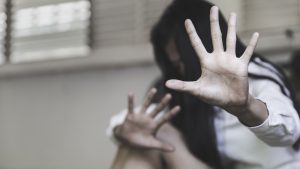 Mulher sentada com a mão aberta contra a violência