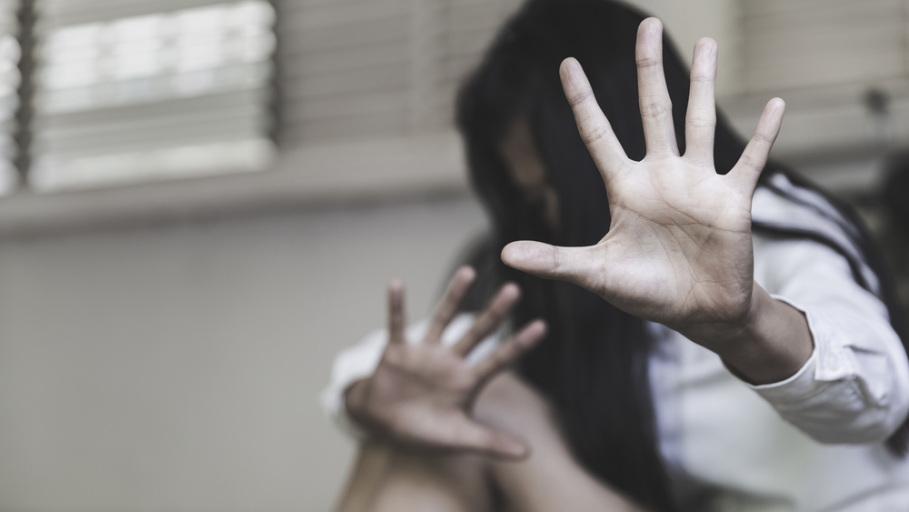 Mulher sentada com a mão aberta contra a violência